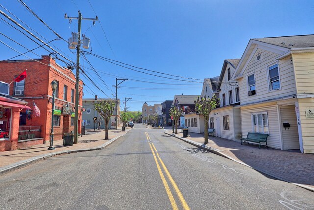 view of street with a residential view, sidewalks, curbs, and street lighting