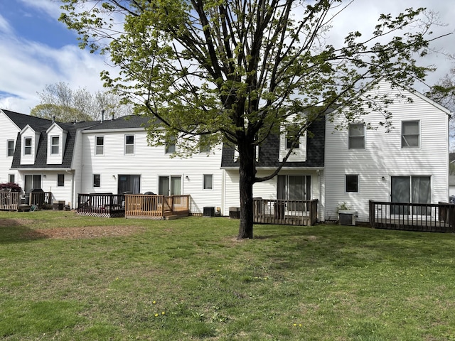 rear view of property with central AC unit, a yard, and a deck