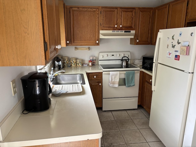 kitchen with brown cabinetry, a sink, light countertops, under cabinet range hood, and white appliances