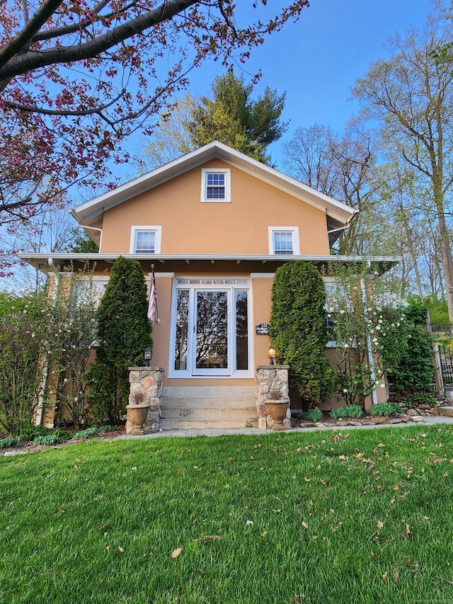 exterior space with a lawn, stucco siding, and entry steps
