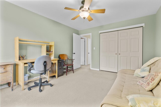 carpeted office with baseboards and a ceiling fan