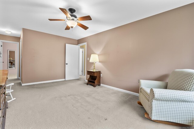 living area with carpet floors, ceiling fan, and baseboards