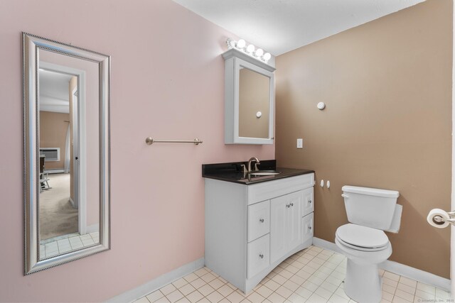 bathroom featuring vanity, baseboards, toilet, and a wall mounted air conditioner