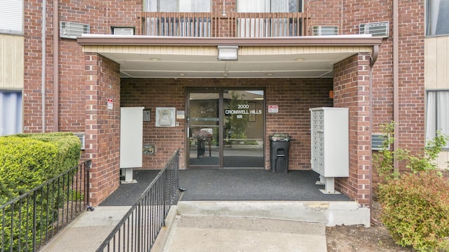 property entrance with brick siding and a balcony