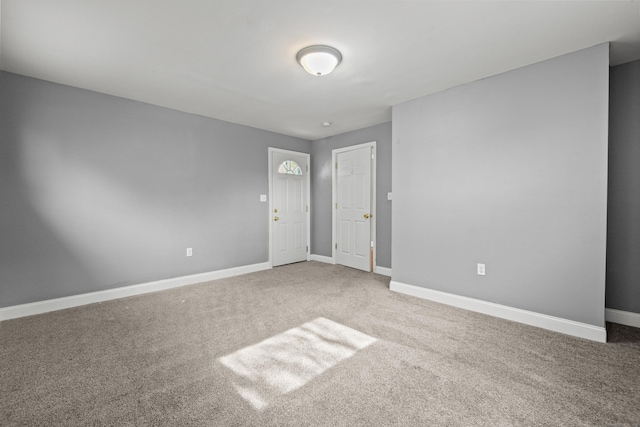 carpeted spare room with baseboards