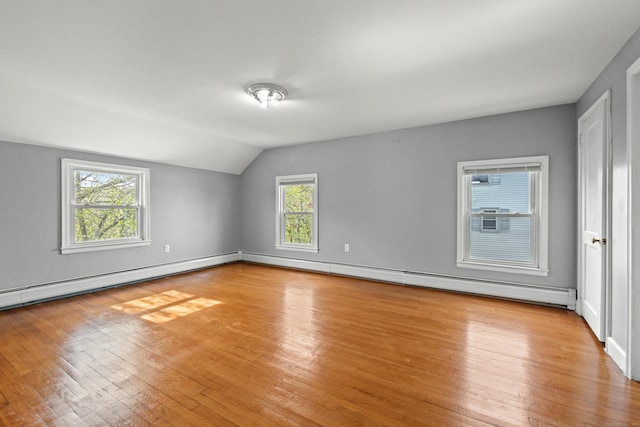 interior space with lofted ceiling, baseboards, baseboard heating, a baseboard heating unit, and light wood finished floors