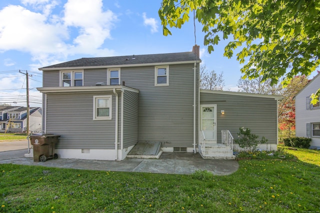 back of property with a yard and a patio