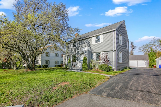 view of front of home with a garage, an outdoor structure, a chimney, and a front lawn