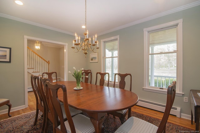 dining area featuring stairway, a baseboard radiator, plenty of natural light, and wood finished floors