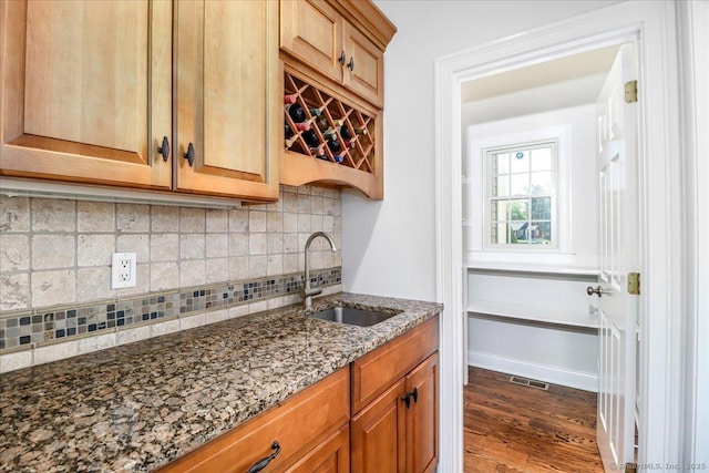 interior space with a sink, dark wood finished floors, tasteful backsplash, visible vents, and bar area
