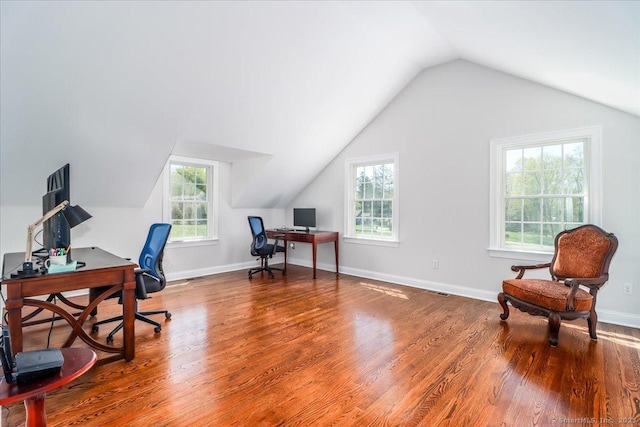 office featuring baseboards, vaulted ceiling, a wealth of natural light, and wood finished floors