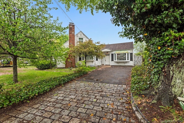 view of front of house featuring a chimney and driveway