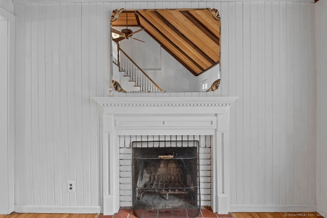 detailed view of wood walls, baseboards, and a fireplace