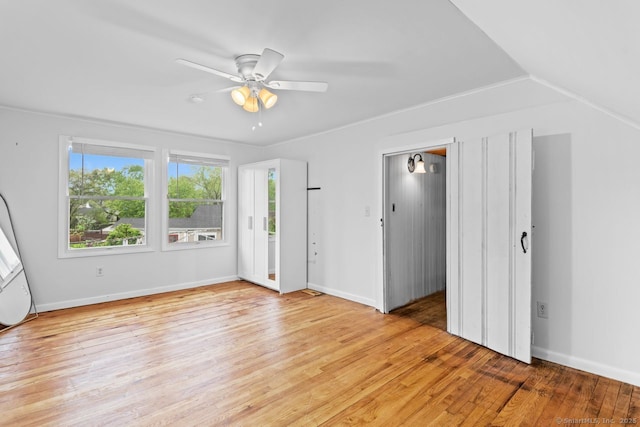 unfurnished room featuring light wood-style flooring, ceiling fan, baseboards, and vaulted ceiling