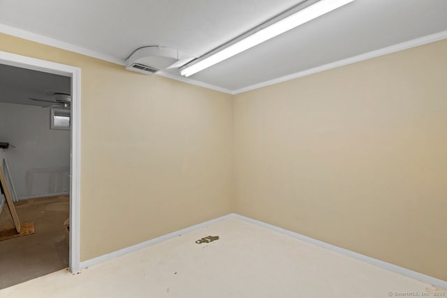 spare room featuring baseboards, concrete flooring, and ornamental molding