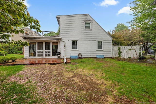 rear view of house with a sunroom and a balcony