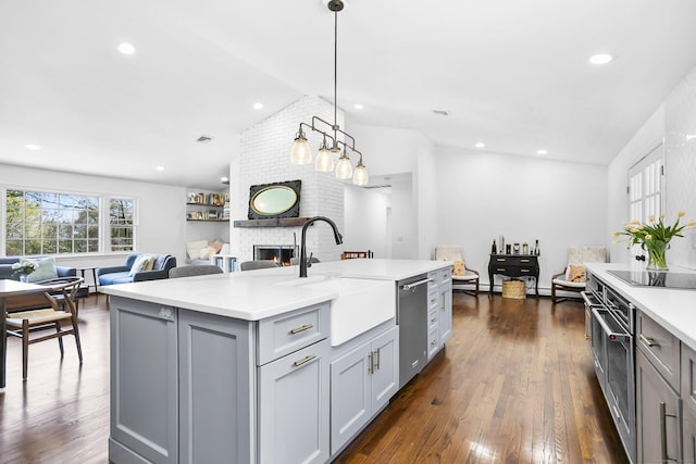 kitchen with a sink, gray cabinetry, a brick fireplace, and dishwasher