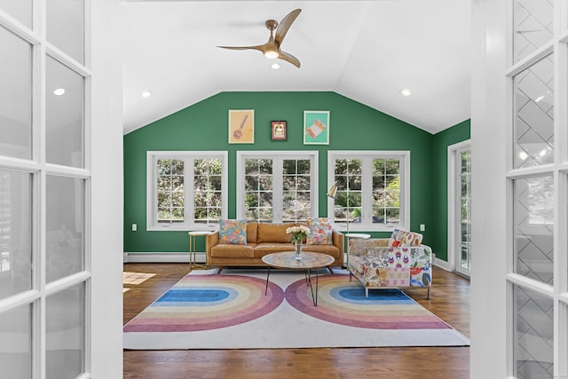 interior space featuring baseboard heating, a ceiling fan, baseboards, wood finished floors, and vaulted ceiling