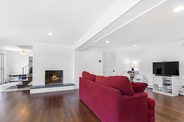 living area with a brick fireplace, recessed lighting, and wood finished floors