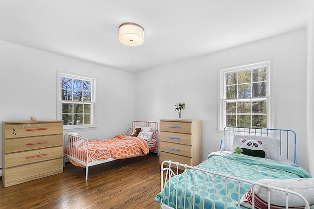bedroom featuring dark wood finished floors and multiple windows