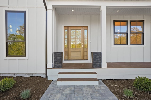view of exterior entry featuring board and batten siding and a porch