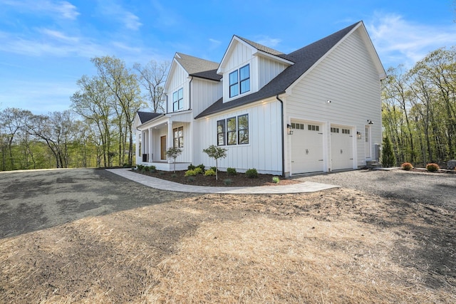 view of home's exterior with roof with shingles, board and batten siding, dirt driveway, and an attached garage