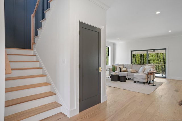 stairway with recessed lighting, wood finished floors, and a healthy amount of sunlight