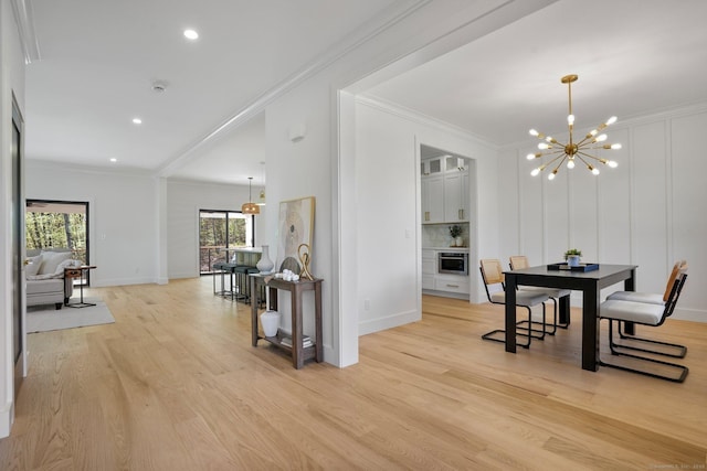dining area featuring crown molding, baseboards, a notable chandelier, and light wood-style floors