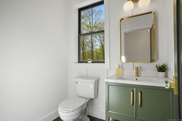 half bath featuring toilet, baseboards, tile patterned flooring, and vanity