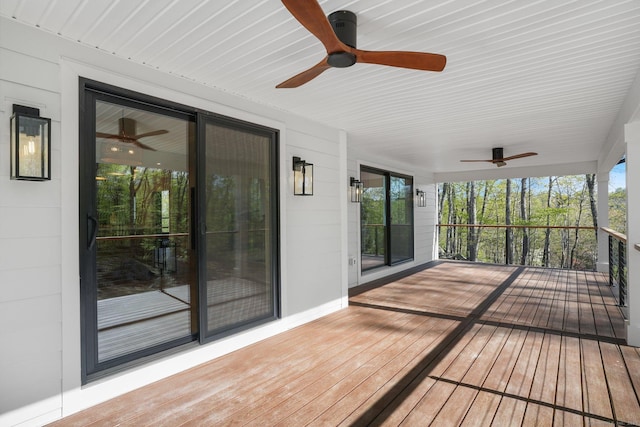 unfurnished sunroom featuring ceiling fan and hardwood / wood-style flooring