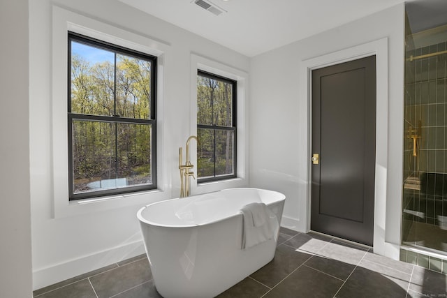 full bath with tile patterned floors, baseboards, a freestanding tub, a shower stall, and visible vents