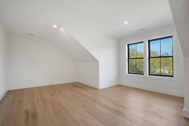additional living space featuring light wood-type flooring, recessed lighting, baseboards, and lofted ceiling