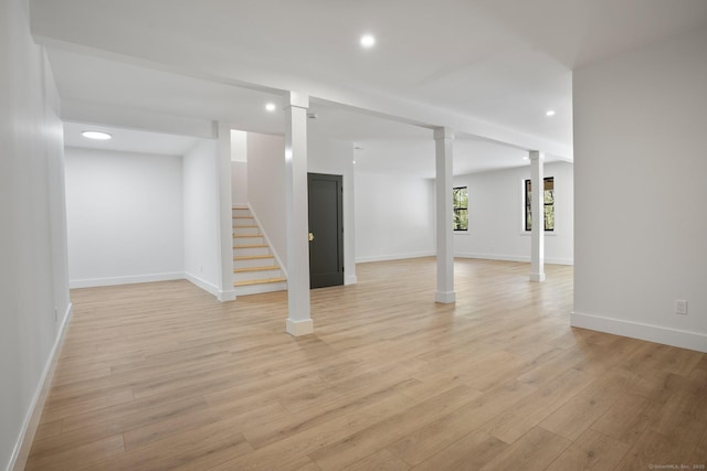 basement featuring recessed lighting, light wood finished floors, baseboards, and stairway
