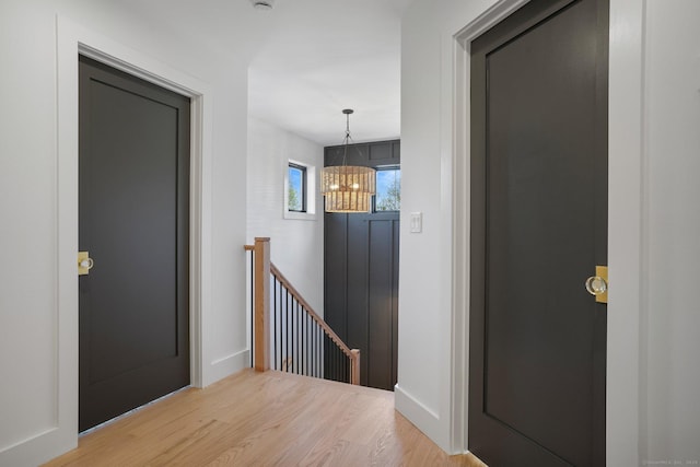 entrance foyer with light wood-style floors, baseboards, and a chandelier