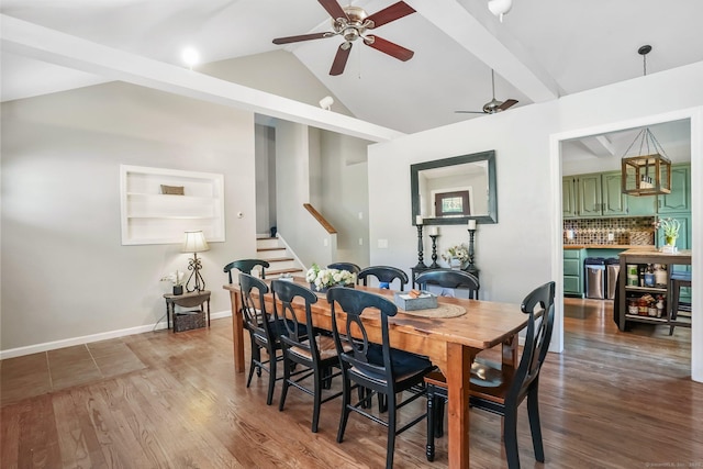 dining room featuring bar, ceiling fan, wood finished floors, stairway, and lofted ceiling