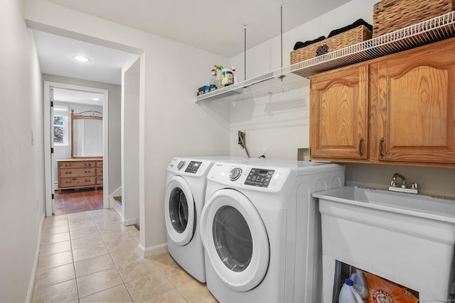 laundry room with cabinet space, light tile patterned floors, baseboards, separate washer and dryer, and recessed lighting