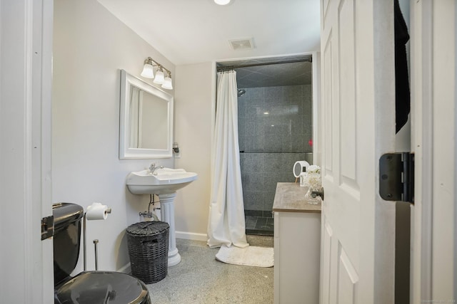 bathroom featuring visible vents, baseboards, and tiled shower