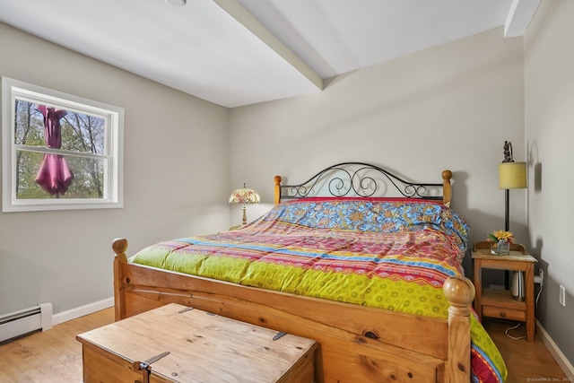 bedroom featuring baseboards, wood finished floors, and a baseboard radiator
