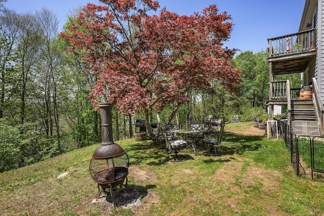 view of yard featuring stairs, a fire pit, and a wooden deck