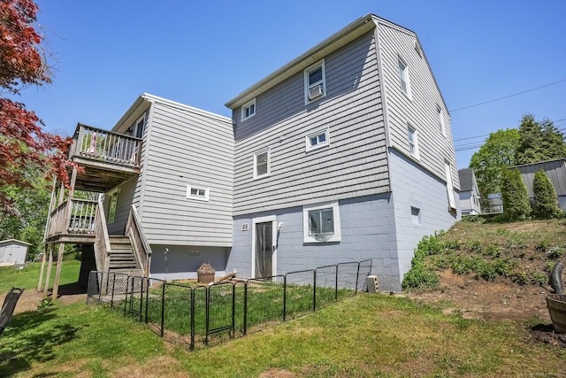 rear view of house with a yard, a deck, stairway, and fence