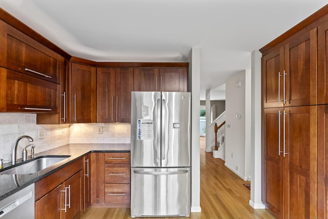 12 Boulevard Dr Unit 21-130, Danbury, CT 06810 - kitchen featuring stainless steel appliances, a sink, dark stone countertops, light wood-style floors, and decorative backsplash