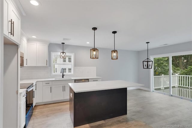 kitchen with a sink, decorative backsplash, stainless steel appliances, and light wood-type flooring
