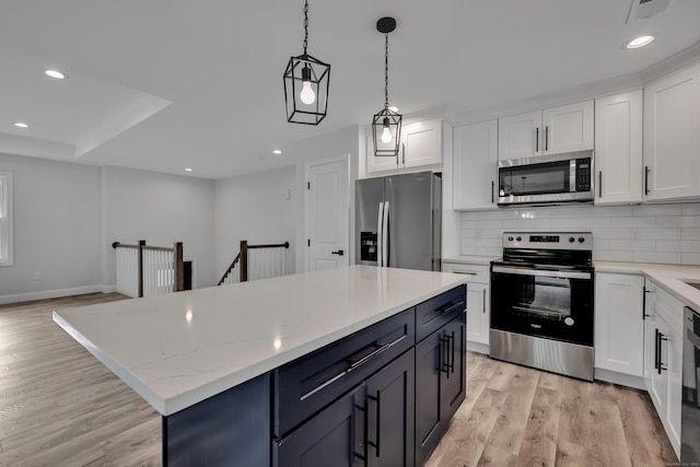 29 Sterling St, New Britain, CT 06053 - kitchen with stainless steel appliances, light wood-style flooring, white cabinets, a center island, and recessed lighting