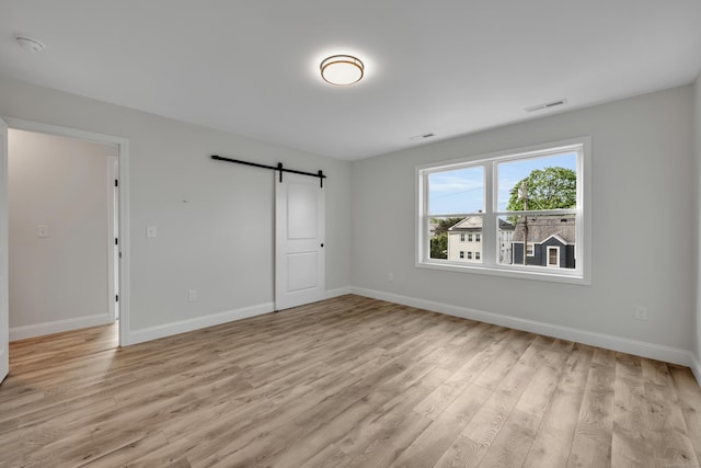 29 Sterling St, New Britain, CT 06053 - unfurnished bedroom featuring light wood-style floors, a barn door, and baseboards