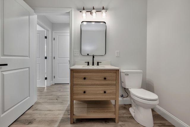 29 Sterling St, New Britain, CT 06053 - half bath featuring wood finished floors, toilet, vanity, and baseboards