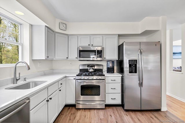 5 Pheasant Run, Guilford, CT 06437 - kitchen with stainless steel appliances, light countertops, light wood-style floors, and white cabinetry