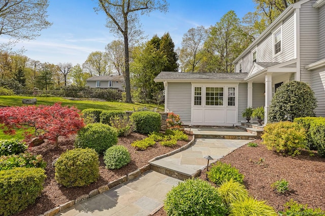 doorway to property featuring fence and a shingled roof