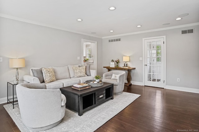 living room featuring visible vents, baseboards, wood finished floors, and a wealth of natural light