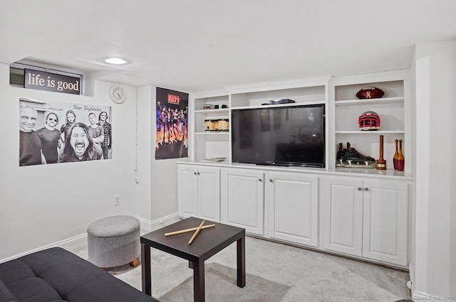 living room featuring baseboards, built in features, and light carpet
