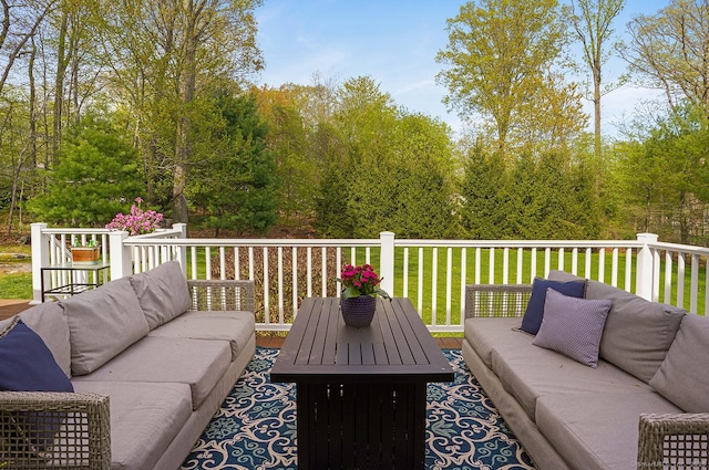 wooden terrace with a lawn and an outdoor living space with a fire pit
